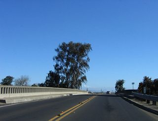 Crossing over California 99, California 233 narrows to two lanes. Note the old-style concrete bridge railing.