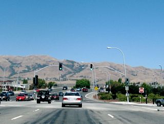 Eastbound California 237 (Calaveras Boulevard) meets Abel Street at this major traffic signal. From here, California 237 crosses over the Union Pacific Railroad tracks on this viaduct.