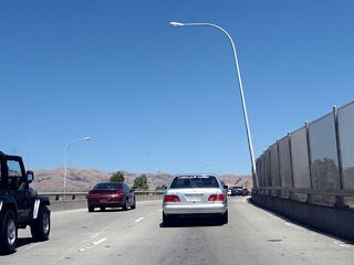 The bridge over the Union Pacific Railroad yard carries two lanes in each direction and limited shoulders. A curve in the roadway limits sight distance on California 237 east.