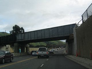 Now in the city of Fremont and prior to the California 84 (Niles Canyon Road) intersection, California 238 (Mission Boulevard) passes under the former Southern Pacific Railroad tracks, which now carries the Niles Canyon Railway for scenic steam train tours through Niles Canyon. Ahead, California 84 departs to the east into Niles Canyon. California 84 west and California 238 south briefly merge to cross Alameda Creek, then split at Mowry Avenue.