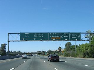 Northbound California 242 reaches Exit 3A, Olivera Road. The left three lanes connect to Exit 3C, California 4 east to Pittsburg, Antioch, and Stockton, while the right lane becomes exit only for Exit 3B, California 4 west to Martinez and Hercules. Use California 4 west to Port Chicago Highway (this is counterintuitive because Port Chicago Highway parallels California 242 to the east of here.