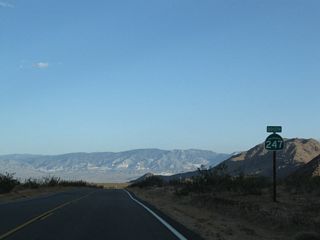 SR 247 curves southeastward by Sidewinder Mountain and lowers to 3,000 feet above sea level across North Lucerne Valley.