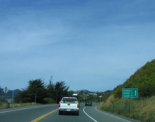 A substandard mileage sign provides the distance to Greenbrae (one mile), Kentfield (three miles), and Sausalito (ten miles).