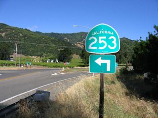 California 253 trailblazer posted on the ramp from northbound U.S. 101 (Redwood Highway) to the state route west along South State Street (former U.S. 101). After crossing the freeway on this bridge, a left turn is required to follow California 253 west to Boonville.