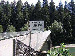 Southbound California 254 (Avenue of the Giants) passes over the South Fork of the Eel River on this 1931 bridge. While the bridge survived the 1964 flood of the Eel River, it was raised and reconstructed in 1966 to mitigate damage after its was determined to be structurally sound. Bridges in the North Coast were ravaged by the storms of 1964, and this one was not exempted from being damaged.