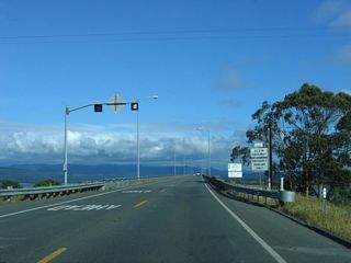 Named in honor of Richard F. Denbo, the Samoa Bridge carries California 255 over Humboldt Bay. A begin freeway sign is posted at the foot of the bridge as California 255 continues east (south) as a two-lane freeway.