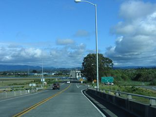 Southbound California 255 - Samoa Bridge reaches the off-ramp for the Woodley Island Marina. No cross traffic is allowed at this interchange. California 255 essentially functions as a Super Two through this interchange.