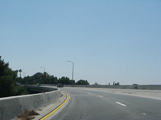 An entrance ramp from adjacent W 30th Street combines with the flyover taking SR 259 south across SR 210. The freeway entrance shields on 30th Street show the route as "To Interstate 215."