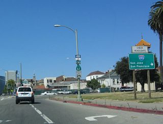 After emerging from the Posey Tube, this end California 61 shield is placed, alongside a freeway sign pointing the way to Interstate 880 (Nimitz Freeway). Continue straight ahead on Harrison Street to enter downtown Oakland.
