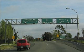 California 260, which is signed as California 61, reaches a right exit to Mariner Square Drive and a left exit to Constitution Way / Marina Village Parkway.