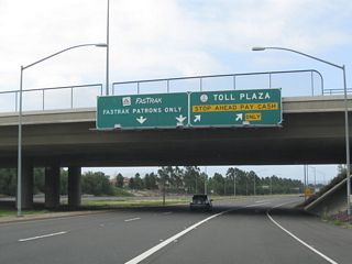 The main lanes of California 261 south split at the Irvine Ranch Toll Plaza. Stay left for FasTrak or exit here for the cash toll plaza. When we went through here in May 2010, the toll plaza had no attendants, just a cash/change machine used to pay the toll.