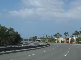 Jamboree Road curves southwest ahead of the signalized interection with Barranca Parkway. The remainder of Jamboree Road south constitutes an urban arterial.