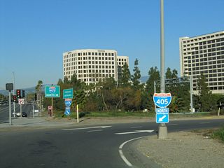 After passing over the busy Interstate 405 freeway, northbound Jamboree Road meets the loop ramp connecting to Interstate 405 northwest to Costa Mesa, Fountain Valley, Westminster, and Long Beach.