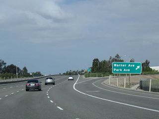 Ramps along Jamboree Road southbound connect with Park Road while the northbound roadway ramps link with Warner Avenue. Jamboree Road leaves Tustin and again enters the city of Irvine at this exchange.