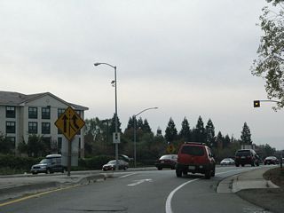 California 262 begins at the modified cloverleaf interchange (built in 1971, widened in 1997) with Interstate 680 in Fremont's Warm Springs district. This view shows traffic from Interstate 680 south merging onto California 262 (Mission Boulevard) west. There are no reassurance shields for California 262, although signage from southbound Interstate 680 lists Mission Boulevard west as part of California 262.