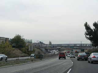 A jersey barrier serves as the median as California 262 continues west under two railroad overpasses and under Kato Road before reaching Interstate 880.