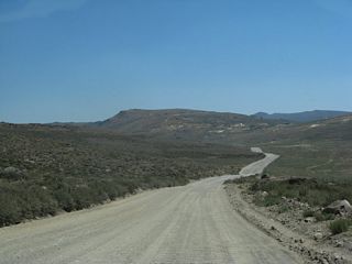 Upon entering the state park, Bodie Road begins to lose elevation for the remaining distance into Bodie. The remnants of the town are visible in the distance as the roadway continues east to town.