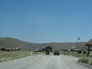 Bodie Road comes to an end at the parking lot for Bodie State Historic Park after the state park fee station. Visitors may park in this gravel lot and walk to the various building preserved within Bodie.
