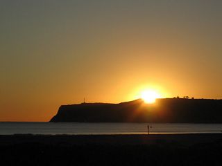 The sun sets over Point Loma on this sunny (and warm) winter day on the beach west of the naval air station. The Cabrillo light house can be seen on the distant horizon.