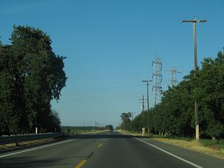 Eastbound Yolo County Route E-6 runs between orchard stands at Martin Ranch east from Road 91A.
