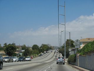 This is a very busy roadway, with limited sidewalks to start and power lines hanging over the travel lanes. There are several approaching side streets, so watch for turning traffic.