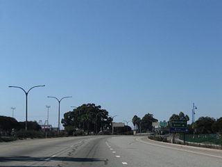 Continuing south across the Queenway Bay Bridge, Queens Way will partition into a left side ramp for the Queen Mary and Cruise Ship Terminal and a right side ramp to the Port of Long Beach and South Waterfront Hotels.