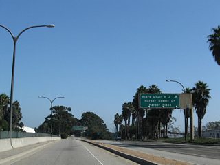 Queens Way south lowers to run alongside Harbor Scenic Drive south to the Queen Mary and Cruise Ship Terminal.