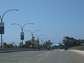 Traffic from Shoreline Drive merges onto southbound Queens Way as the freeway proceeds south over the mouth of the Los Angeles River. The Queensway Bay Bridge opened to traffic in 1969.