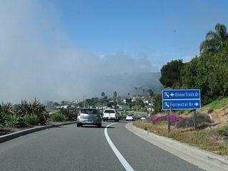 Coastal fog rolled into the area on this late morning in Rancho Palos Verdes. On the south side of the road is the championship Trump National Golf Course and its towering flagpole.