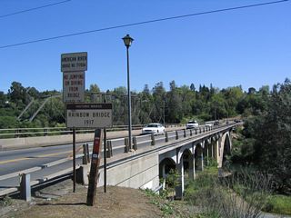 Views of the Rainbow Bridge over the American River as seen along southbound. The bridge was constructed in 1917 and is situated next to an even older truss bridge that today serves as a pedestrian and bicycle bridge. These bridges are located just north of downtown Folsom.