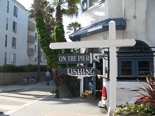 A fishing sign is posted from the Beach Walk at the base of the Crystal Pier arch.