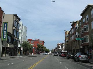 Eastbound Bay Street approaches Mason Street. Parking for the shopping center on the northeast corner is located on the roof of the center.
