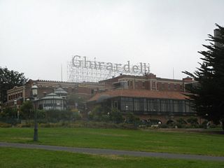 The landmark Ghirardelli Square marquee looms above the chocolate factory that sits above Fisherman's Wharf and the San Francisco Maritime National Historical Museum.