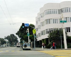 Northbound Van Ness Avenue meets Bay Street. While U.S. 101 turned left from Van Ness Avenue two blocks south of here at Lombard Street, westbound Bay Street and Marina Boulevard (around the south side of Fort Mason and Marina Green) can be used as an alternate route, since Marina Boulevard joins U.S. 101 on the approach to the Golden Gate Bridge.