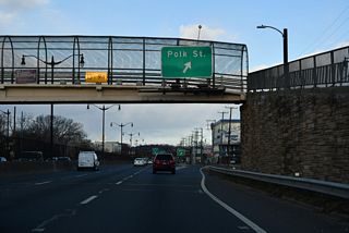 A slip ramp provides access from D.C. 295 north onto parallel Kenilworth Avenue NE ahead of Polk Street. Polk street leads just one and half blocks east from the frontage street to Olive Street NE and a dead end at the Metro Orange Line.