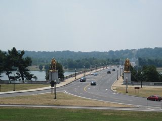 Loop ramps join the east end of the Arlington Memorial Bridge with Lincoln Memorial Circle and Ohio Drive below. The stone arch bridge was constructed in 1932 and previously carried U.S. 50 and U.S. 240. The Arts of War sculptures adorn the bridge ends.