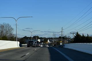 A pair of girder bridges carry the four lanes of SR 1 above Oyster House Road, waters of the Lewes and Rehoboth Canal, and SR 1B (Roosevelt Street).