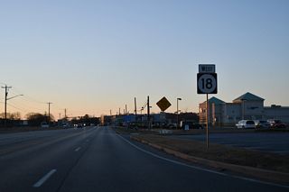 Reassurance marker for SR 18 posted west of U.S. 113 (Dupont Boulevard) in Georgetown. Road work from Fall 2025 to Spring 2028 replaces the traffic light at SR 18/404 and U.S. 113 with a parclo B2 interchange.