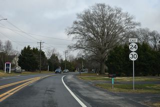 SR 24 curves east from Godwin School Road (Rd 328A) along Laurel Road past the Plantation Lake I subdivision to U.S. 113/SR 20 in Millsboro. SR 30 was decommissioned along SR 24 in 2022, but a new shield for the route was added here in 2025.