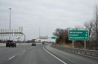 A distance sign 32 miles southwest of Philadelphia, Pennsylvania was added beyond the I-495 overpasses in 2024. Historically an entrance ramp linked I-495 south with I-95 here.
