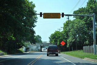 Warning beacons preceding the low clearance overpass carrying the CSX Railroad across Casho Mill Road southbound.