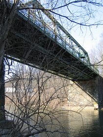A 25 foot long stone arch and a 127 foot long truss support the bridge deck. The 1833 stone arch at the west end of the Rising Sun Bridge originally spanned a mill race.