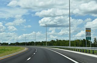 While generally traveling west, SR 23 curves northward from U.S. 17 across CR 15A (Oakridge Avenue).