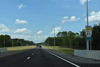 Curving northwest, SR 23 crosses Black Creek ahead of this confirming marker at Rideout Point Preserve.