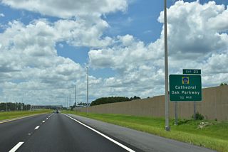 Separating the toll road from the Rolling Hills development, a large sound wall lines the west side of SR 23 from the CR 739B (Sandridge Road) underpass southward to the Sandridge Plaza all-electronic toll (AET) gantry.