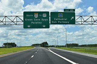 Signed as CR 216 at Exit 23, Cathedral Oak Parkway weaves west through areas of future development to a roundabout with CR 218 and east to CR 315 near Green Cove Springs.