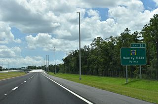 SR 23 spans Black Creek before turning east into the diverging diamond interchange (Exit 28) with CR 739 (Henley Road).