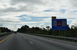 Two miles ahead of the Okahumpka Service Plaza on the Turnpike south. The area is typical of those on the toll road, lying between the north and southbound roadways.