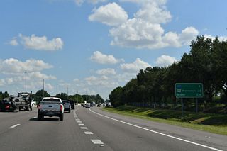 Distance sign posted ahead of the separation with SR 408 (East West Expressway) highlighting the interchanges with Interstate 4 and U.S. 192 (and U.S. 441) in Kissimmee.
