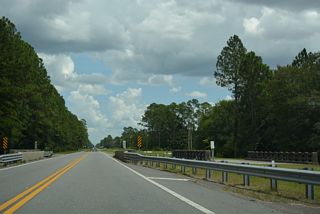SR 230 crosses a tributary of Alligator Creek east of CR 230A. The first of two abandoned bridges parallel the south side of the highway.